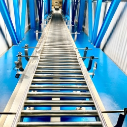 BĂNG TẢI NÂNG HẠ CHUYỂN THÙNG QUA NHÀ KHO - The lifting conveyor transfers carton boxes to the wareh